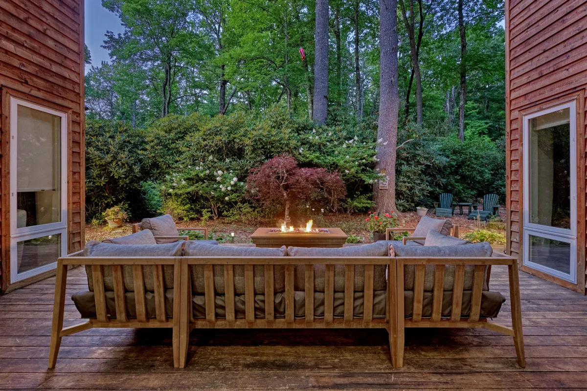 A cozy outdoor fire pit surrounded by comfortable seating and lush greenery, creating an inviting spot to gather, socialize, and enjoy the tranquility of the outdoors—especially under the stars.